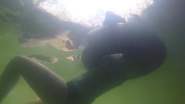 Eine Frau, die in einer Röhre im Wasser schwimmt — Stockvideo