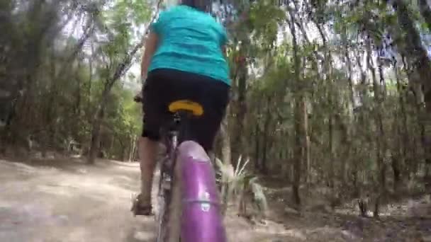 Una mujer monta una bicicleta en un camino de tierra — Vídeo de stock