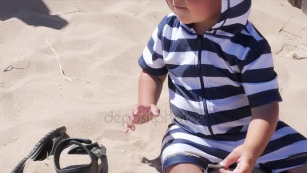 Adorável menino brincando na praia de areia — Vídeo de Stock