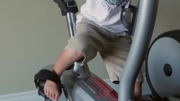 Chico jugando en bicicleta estática — Vídeos de Stock