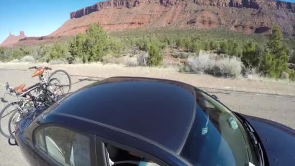 Coche conduciendo a través de un desierto con bicicletas — Vídeo de stock