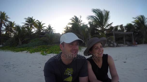 Пара сидит на красивом тропическом пляже — стоковое видео