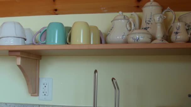 Cups on a shelf in home — Stock Video