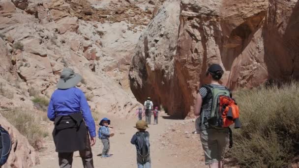 Family hiking through a desert slot canyon — Stock Video