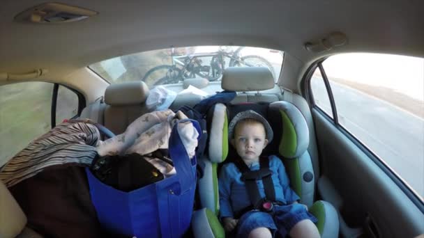 Семья с ребенком, путешествующим на автомобильном сидении — стоковое видео