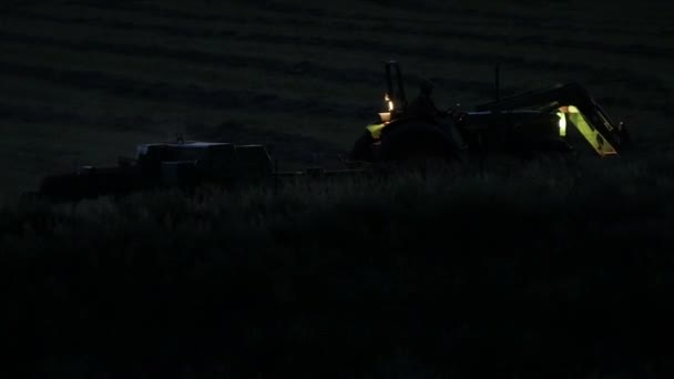 Farmer bailing hay in late night — Stock Video