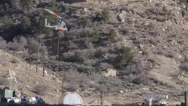 Helicóptero que lleva suministros de construcción — Vídeo de stock