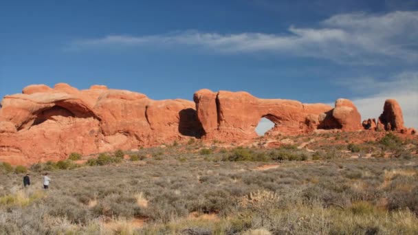 Hikers walk by north window arch — Stock Video