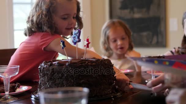 Niños en una fiesta de cumpleaños con pastel de chocolate — Vídeo de stock