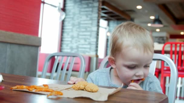 Menino comendo em um restaurante fast food — Vídeo de Stock