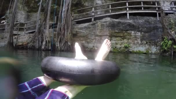 Man floats in tube in cenote — Stock Video