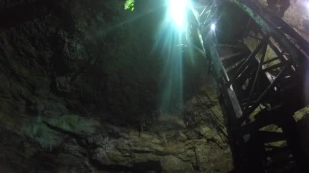 Homem salta em um cenote subterrâneo — Vídeo de Stock