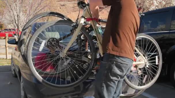Muž páskování kolo na nosič kol — Stock video