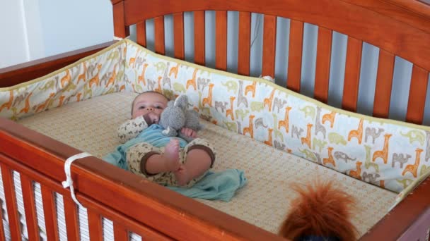 Новорожденный мальчик лежит в кроватке — стоковое видео