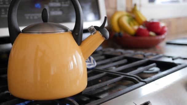 Hervidor de té amarillo en la estufa — Vídeo de stock