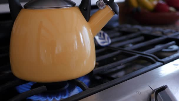 Hervidor de té amarillo en la estufa — Vídeos de Stock