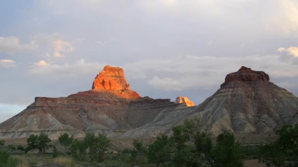 Nubes de lluvia por encima de una butte desierto al atardecer — Vídeos de Stock