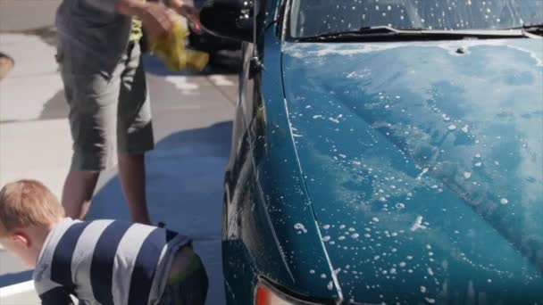 Toddler helping mother wash car — Stock Video