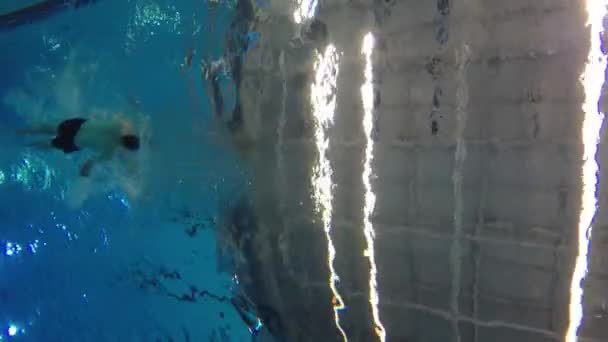 Mann schwimmt Rückenschwimmen im Pool — Stockvideo