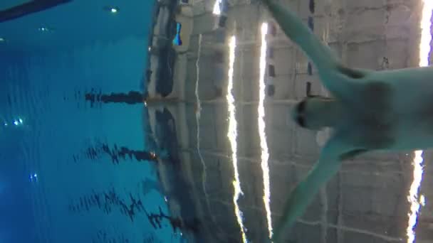Mann schwimmt durch Wasser am Pool — Stockvideo