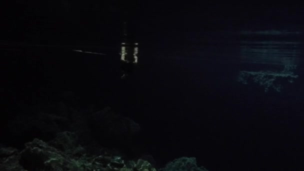 Ung kvinna bada i mörka Cenote — Stockvideo