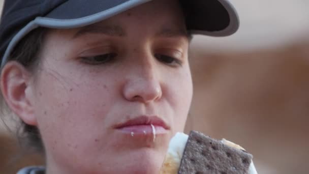 Kvinna som äter en marshmallow SMER runt elden — Stockvideo