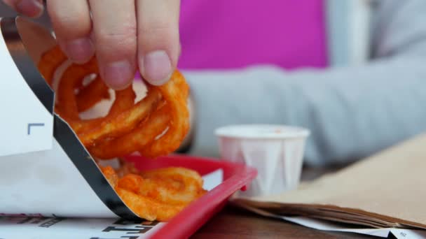 Mujer comiendo papas fritas en un restaurante de comida rápida — Vídeo de stock