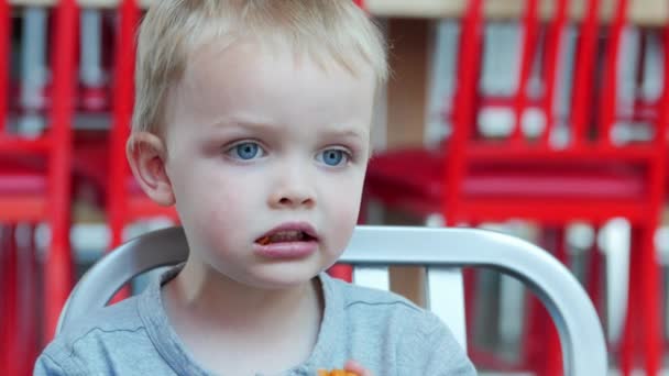 Boy eating fast food at table — Stock Video