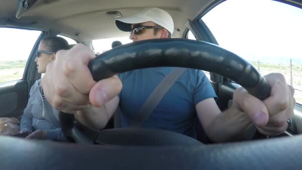 Νεαρό ζευγάρι οδηγώντας σε ένα αυτοκίνητο — Αρχείο Βίντεο