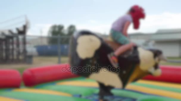 Girl Riding Electronic Bull Rural Fair Rides Activities Blurred — Stock Video