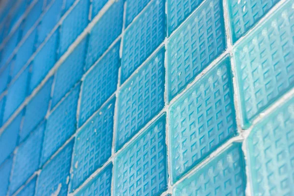 Decoratieve en glanzende glazen blok venster in blauw als een patroon of achtergrond. De muur. Geometrische achtergrond. — Stockfoto