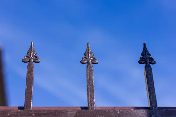 Metallic forged fence in the garden with spikes. — Stock Photo, Image