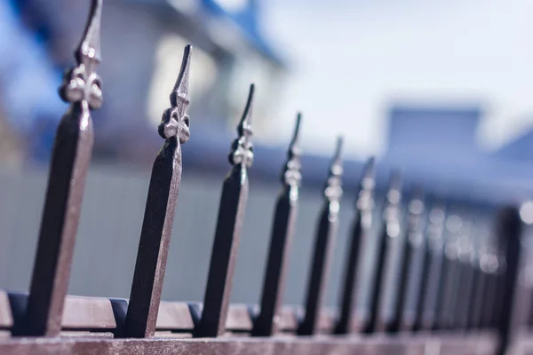 Metallic forged fence in the garden with spikes. — Stock Photo, Image