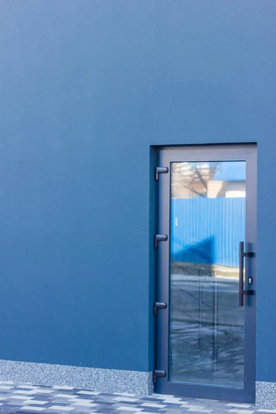 A porta matizado de vidro com uma moldura cinza no edifício de escritórios . — Fotografia de Stock