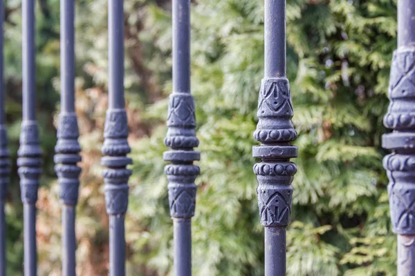 Elements of black metallic forged fence in the garden with spikes. — Stock Photo, Image