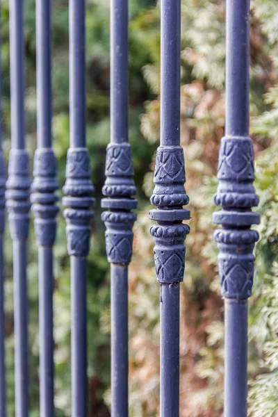 Elements of black metallic forged fence in the garden with spikes. — Stock Photo, Image