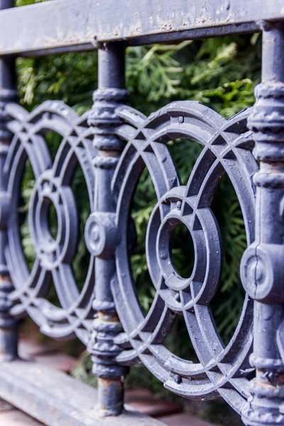 Elements of black metallic forged fence in the garden with spikes. — Stock Photo, Image