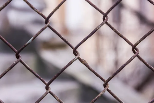 Eslabón de cadena de acero oxidado o malla de alambre como pared límite. Todavía hay una pared de bloque de hormigón detrás de la malla . — Foto de Stock