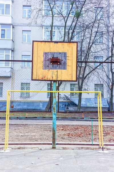 Um velho campo desportivo no pátio. Anel de basquetebol. Portões para futebol — Fotografia de Stock