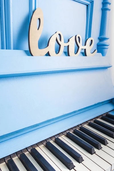 Blaue Piano-Nahaufnahme mit schwarz-weißen Tasten mit Text Liebe ist — Stockfoto