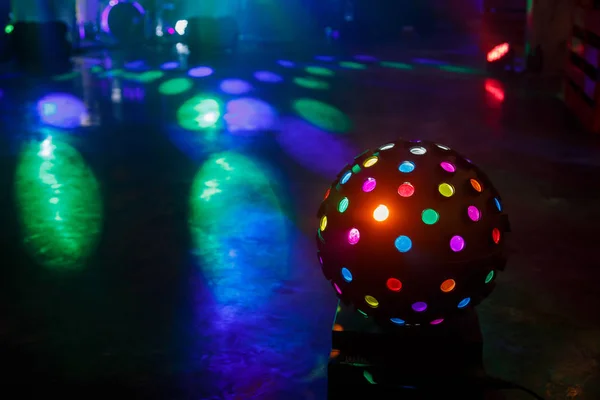 La palla della discoteca brilla sulla pista da ballo. Raggi multicolori Foto Stock Royalty Free