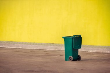 Gezici bir y zemin üzerine yeşil plastik çöp konteyner