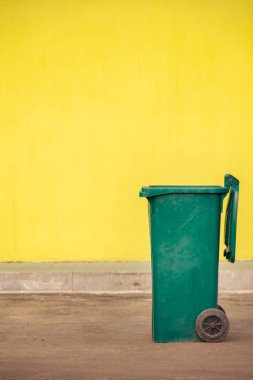 Gezici bir y zemin üzerine yeşil plastik çöp konteyner