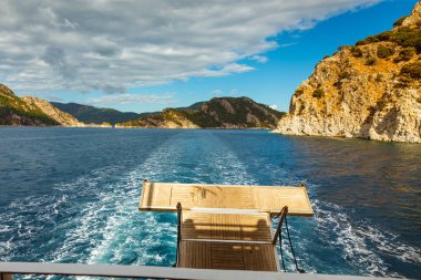 Yatlar seyir ile Ege Denizi ağaçlarda kayalık sahil. 