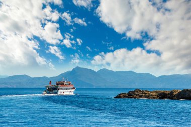 Büyük yat a ağaçları ile kayalık sahil yakın yüzen