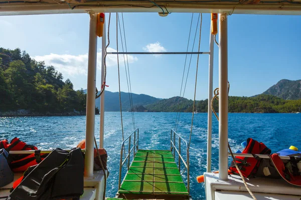 Looking to Rocky coast with trees in the Aegean Sea from yacht.