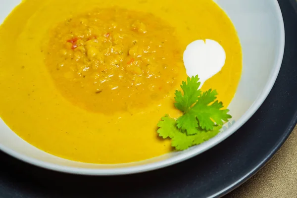 Чечевичный суп в керамической белой миске на золотом фоне — стоковое фото