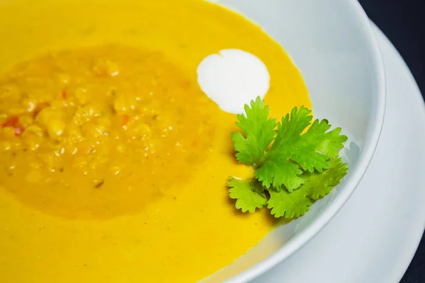 Чечевичный суп в керамической белой миске на золотом фоне — стоковое фото