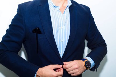 İşadamı uymak yakın çekim. Moda aksesuarları elleri ile rahat bez elbiseli genç işadamı yakışıklı modeli adam portresi