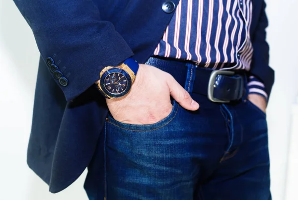 Hand in pocket with wrist watch in a business suit close up.Closeup fashion image of luxury watch on wrist of man.body detail of a business man.Man\'s hand in grey shirt with cufflinks in pants pocket